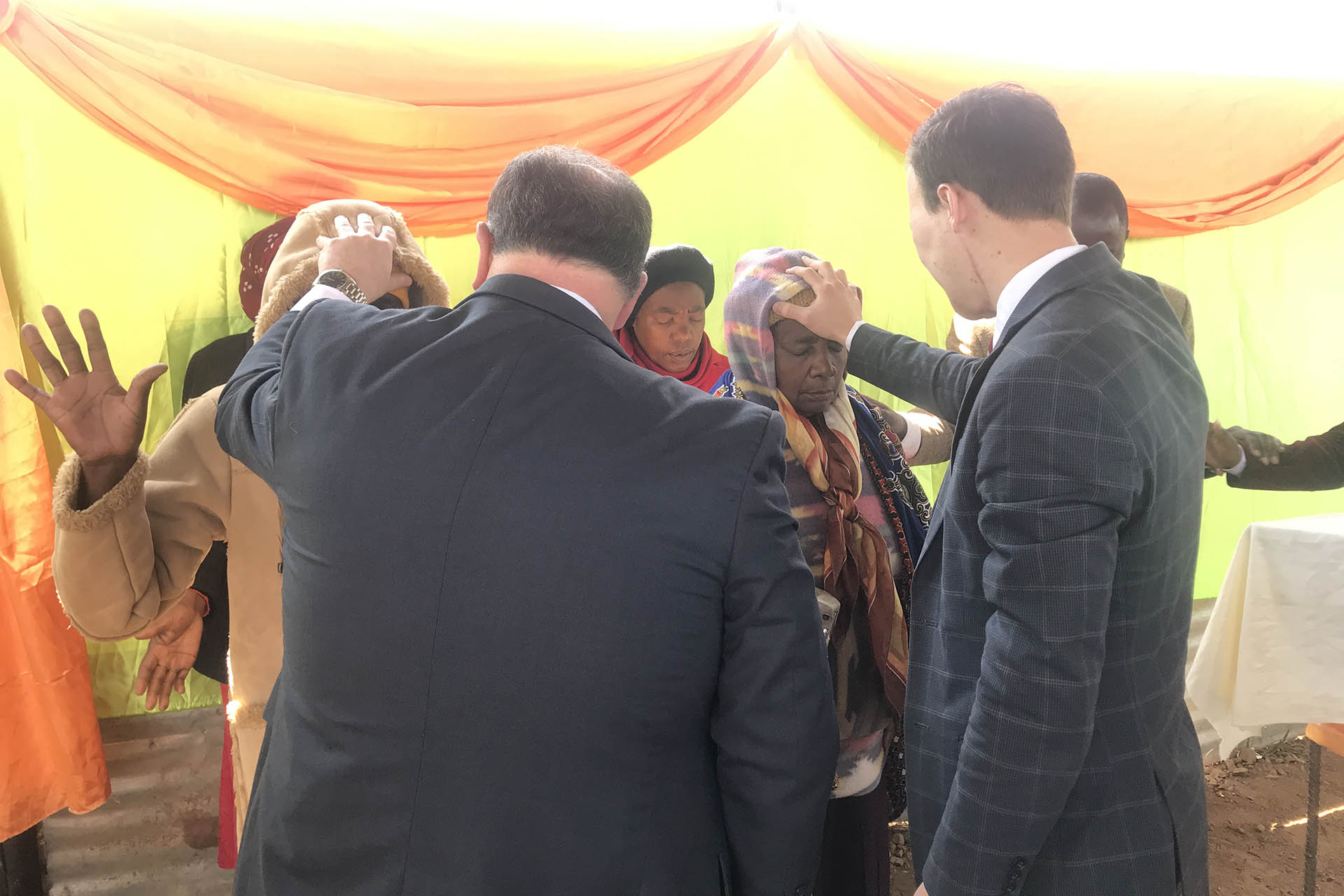 Bishop Gregory Riggen and Rev. Jared Hilton praying for a group of people following a Sunday morning service in Morningside, Bulawayao, Zimbabwe c. 2017